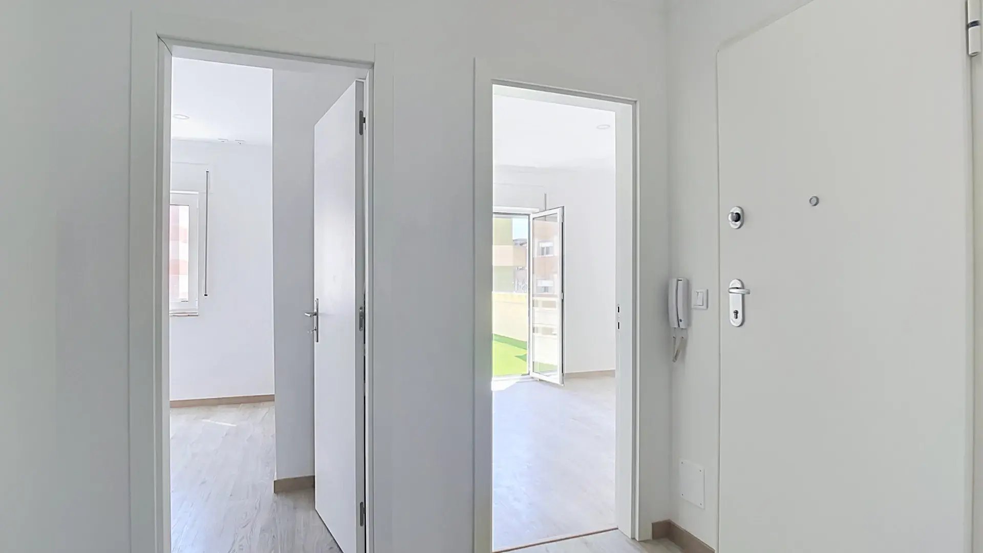 Bright entrance hallway with light wood floors looking toward rooms and terrace in Massamá