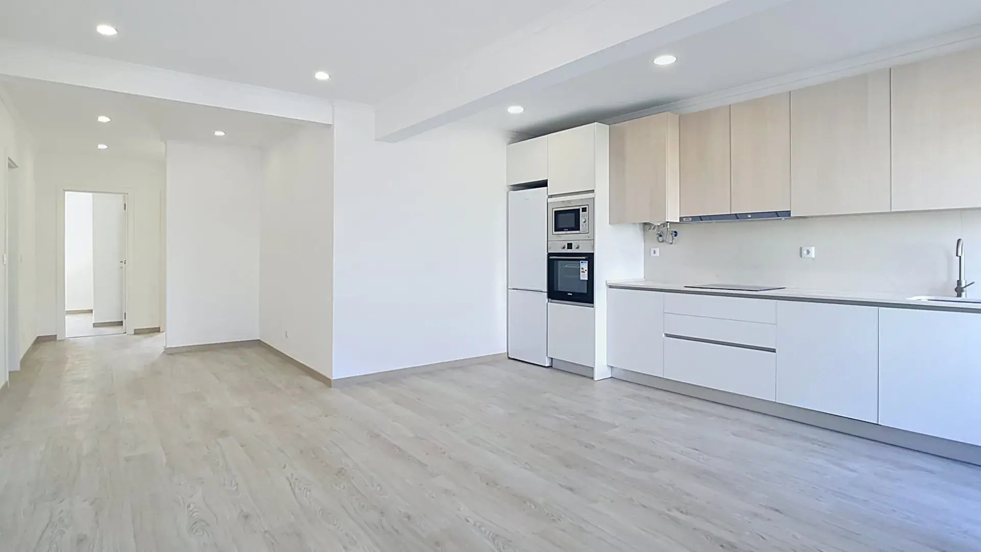 Kitchen run with integrated oven stack and fridge in the renovated Massamá apartment