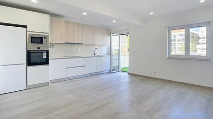 Fully renovated kitchen opening onto a light-filled living space with terrace access in Massamá