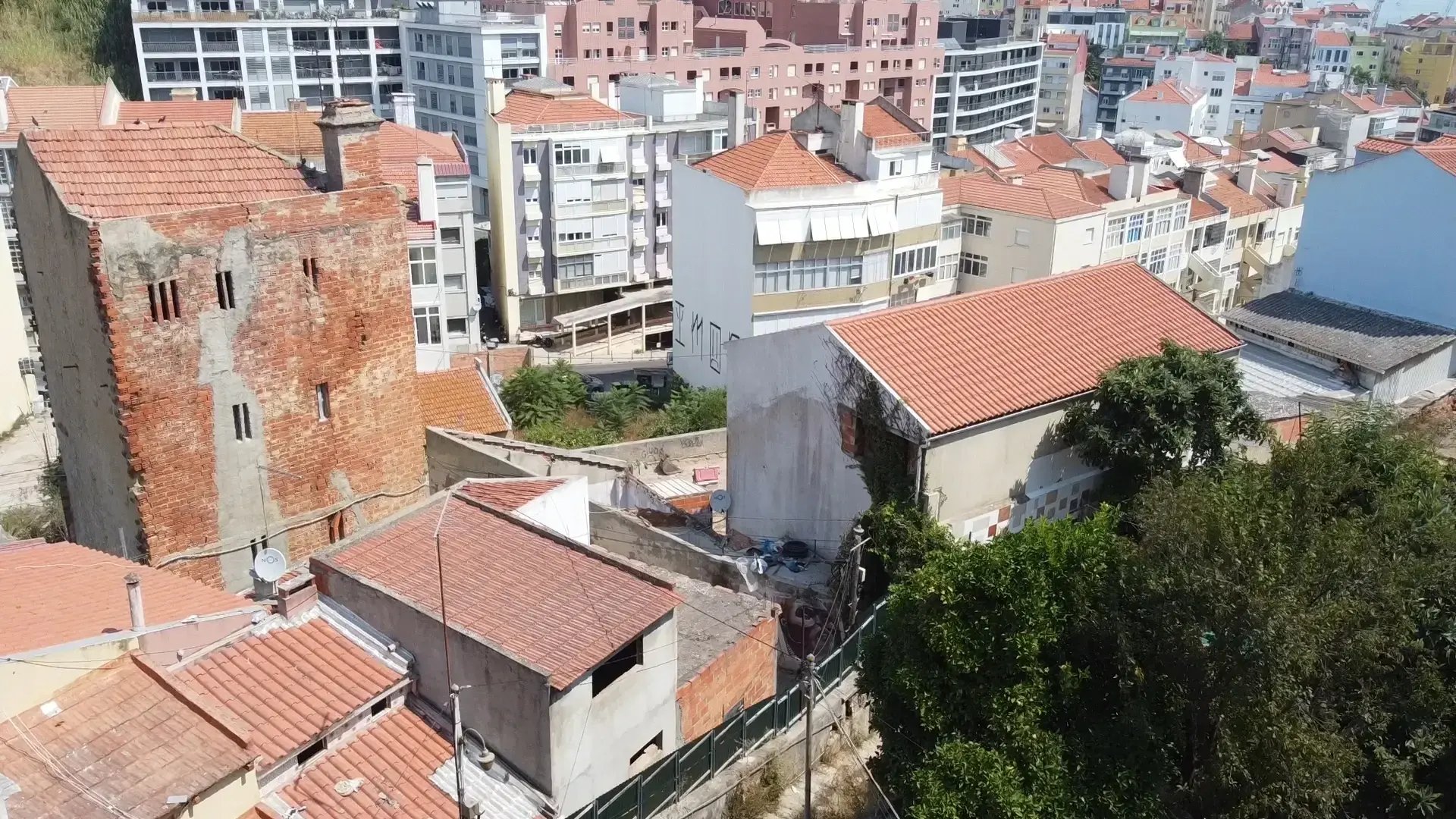 Elevated view of Quinta do Ferro with brick structure and terracotta roofs, São Vicente, Lisbon.
