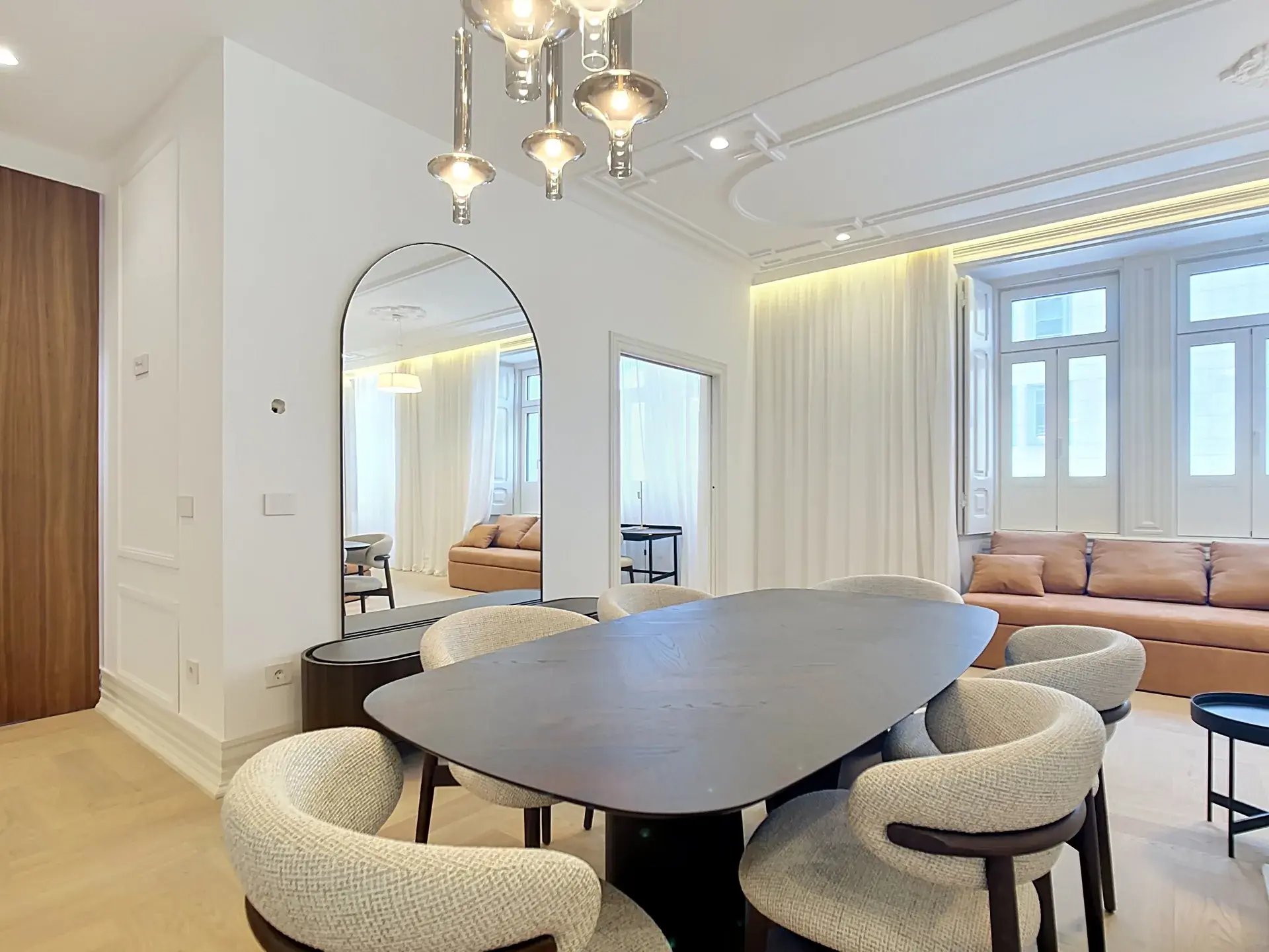 Contemporary dining area with dark wood table and bouclé chairs in a premium apartment in Avenidas Novas, Lisbon