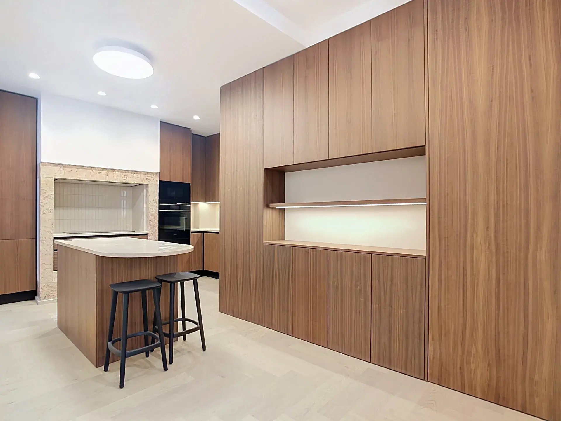 Modern kitchen with floor-to-ceiling wood cabinetry, island and herringbone flooring in Almirante Tridente, Lisbon