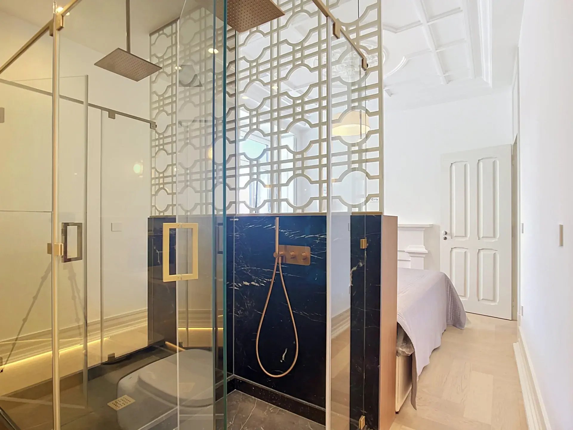 En-suite bathroom with walk-in shower, black marble and decorative lattice screen adjoining the master bedroom