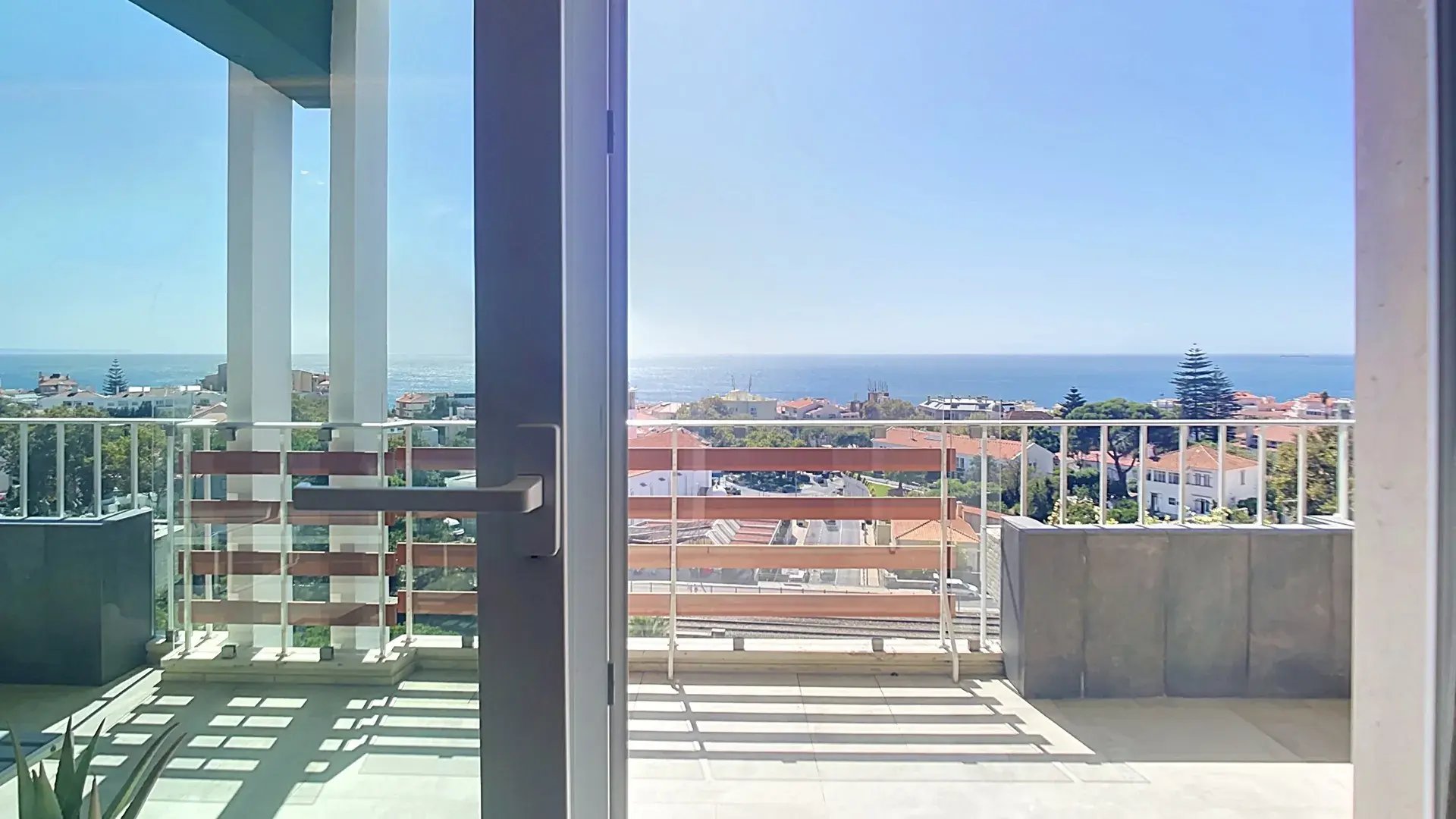 Sliding doors from the living room onto the south terrace, with the Atlantic beyond the railing