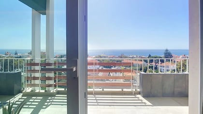 Sliding doors from the living room onto the south terrace, with the Atlantic beyond the railing