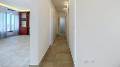 Hall and circulation beside the living room, with stone floors and a built-in bookcase