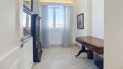 Study with a wooden desk and a window over Parede, usable as a flexible room