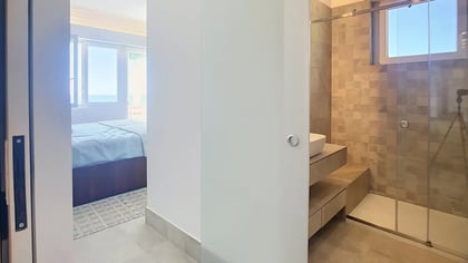 Bedroom seen from the doorway, with a raised sleeping area and stone floors