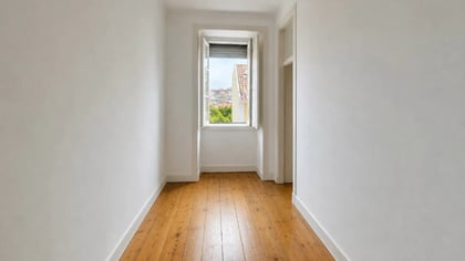 Room under renovation with paint buckets, floor protection, and open door to a hallway.